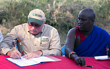 Azzedine Downes, International Fund for Animal Welfare (IFAW) President (left) and Mr. Daniel Leturesh,  representing the Maasai: sign the Kitenden Corridor certificates after they signed a lease agreement, 17 July 2013, in Amboseli National Park in Kenya. Photograph © IFAW/K. Prinsloo.